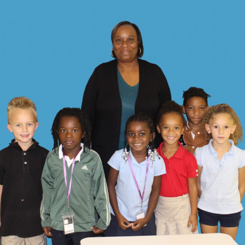 Mrs. Wilcox and her first-grade students pose for a group photo.