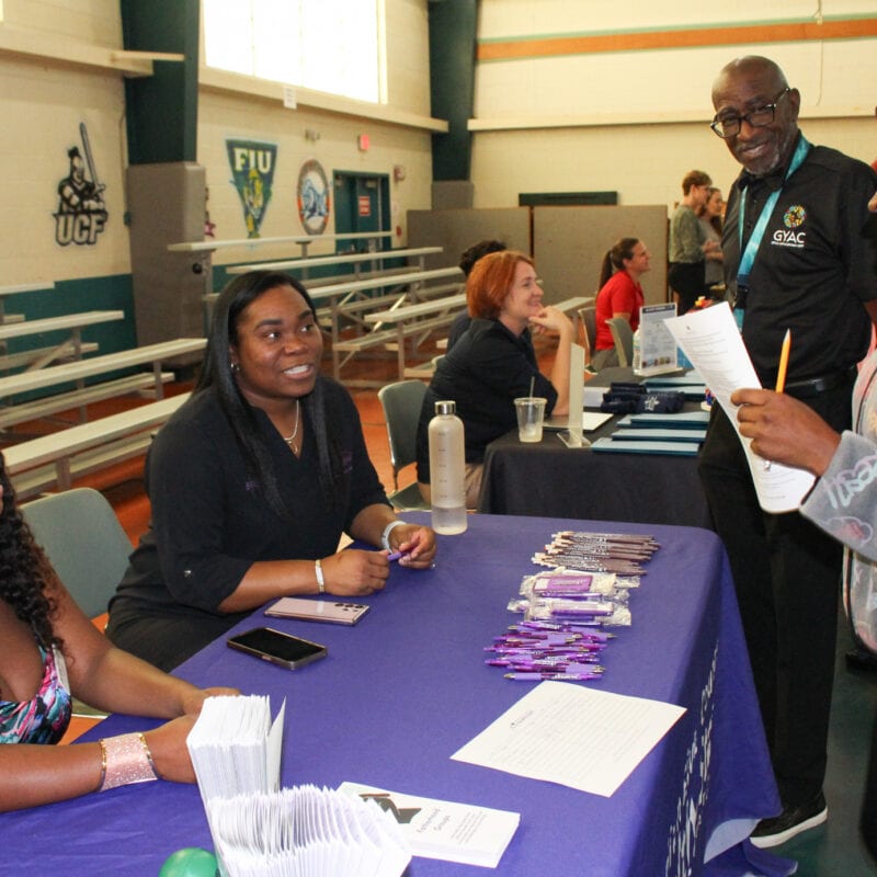 YEP student speaking with the Director of GYAC's Youth Employability Program (YEP) and Indian River County Health Start Coalition's representatives at the Meet and Greet Career Showcase